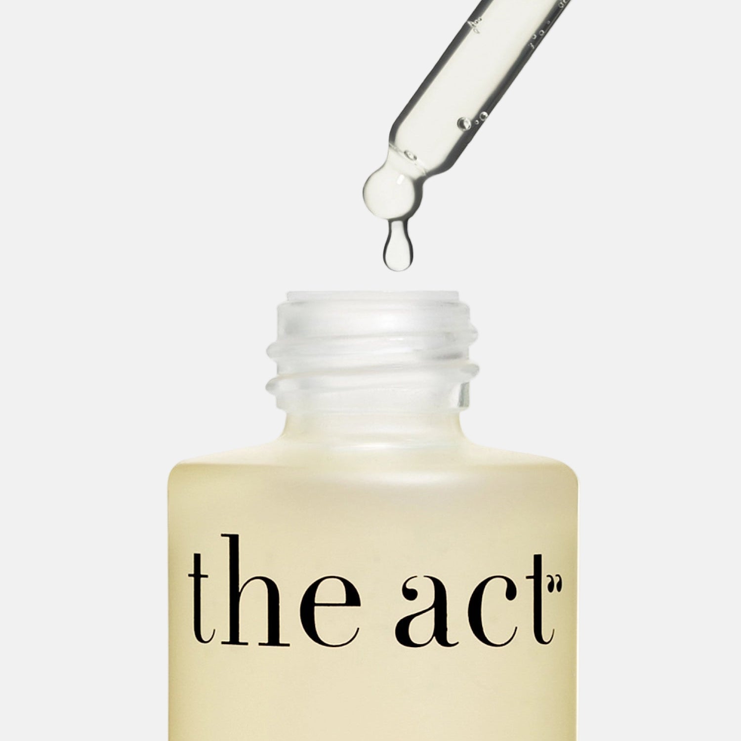 Skincare dropper bottle labeled 'the act' with a droplet being applied.