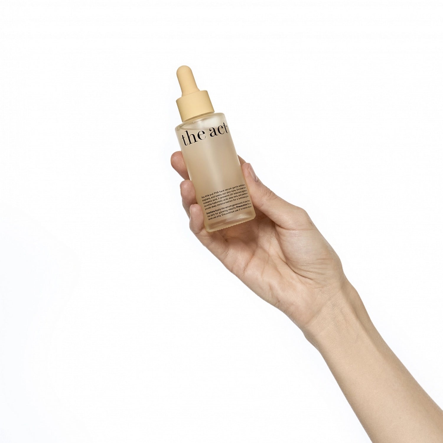 Hand holding a bottle of 'the face shop' skincare product on a white background