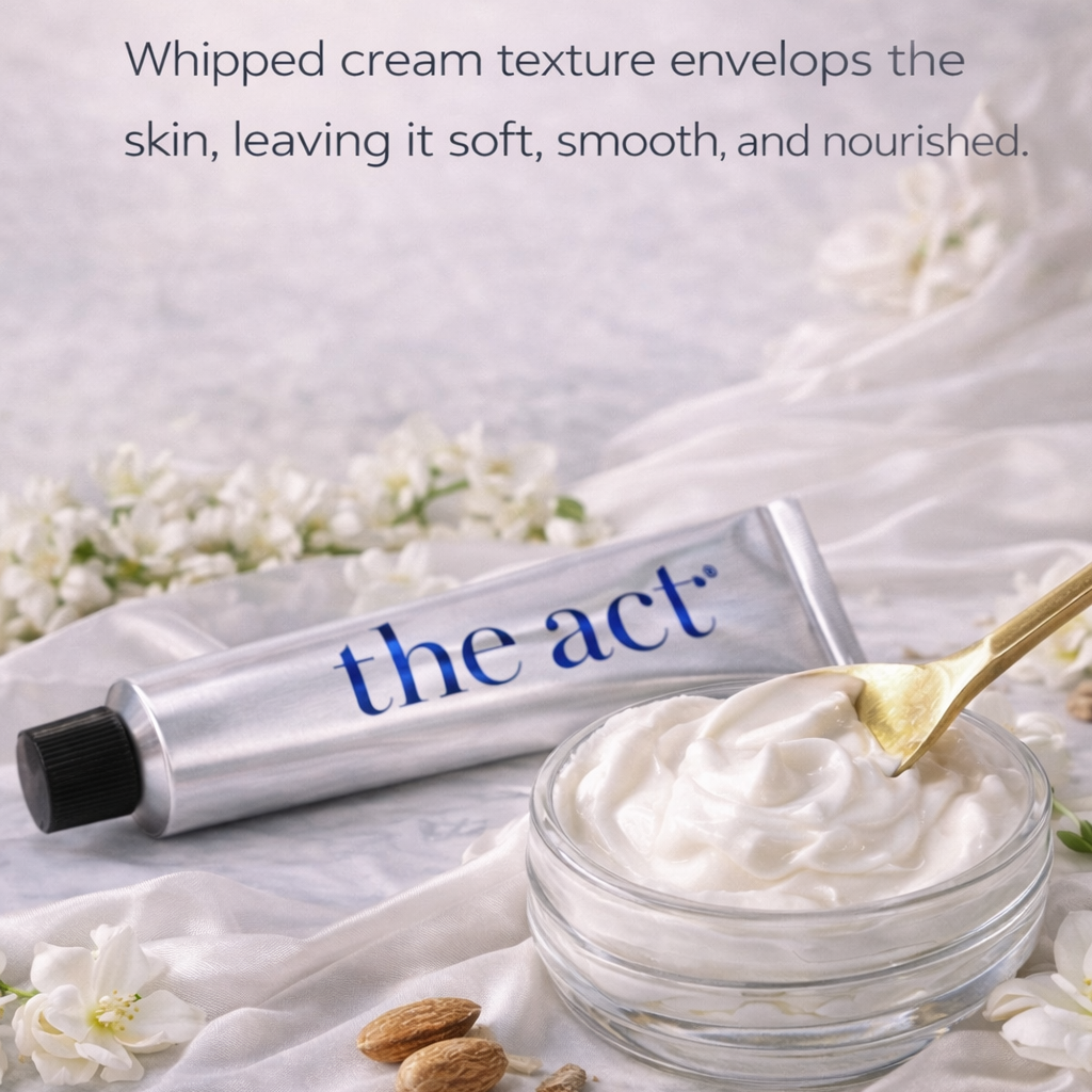 Jar of whipped cream with a tube labeled 'the act' on a light fabric background with flowers.