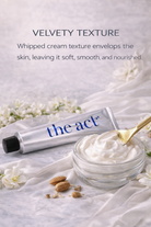 Jar of whipped cream with a tube labeled 'the act' on a light fabric background with flowers.